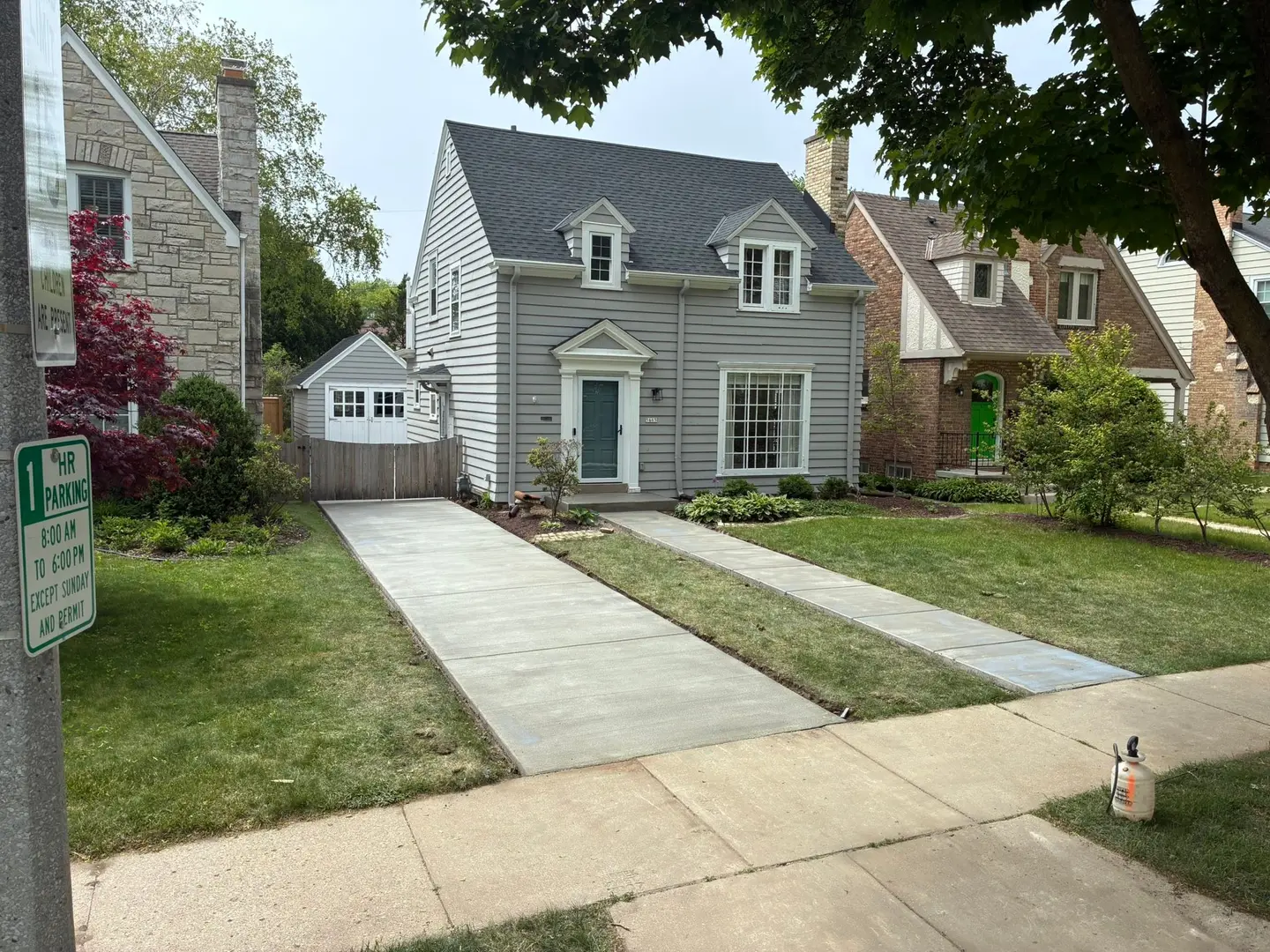 Finished residential concrete driveway and walk leading to a detached garage