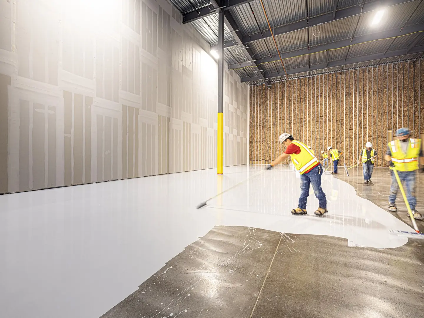 Commercial crew finishing a large floor inside an active facility